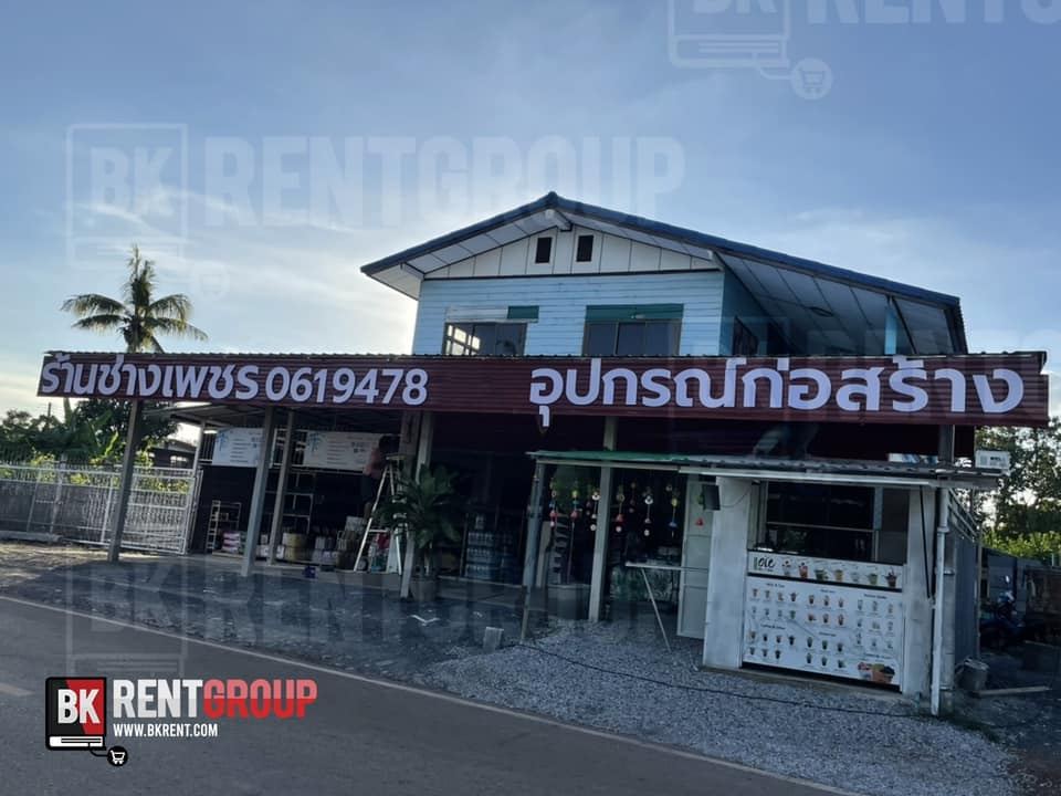 หน้าร้านช่างเพชร อาคารสีฟ้าขาว ป้ายชื่อร้านและป้ายอุปกรณ์ก่อสร้างสีน้ำตาลแดงริมถนน