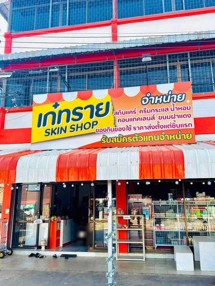 หน้าร้านเก๋ทราย SKIN SHOP ป้ายชื่อร้านสีเหลืองส้มเหนือหน้าร้าน