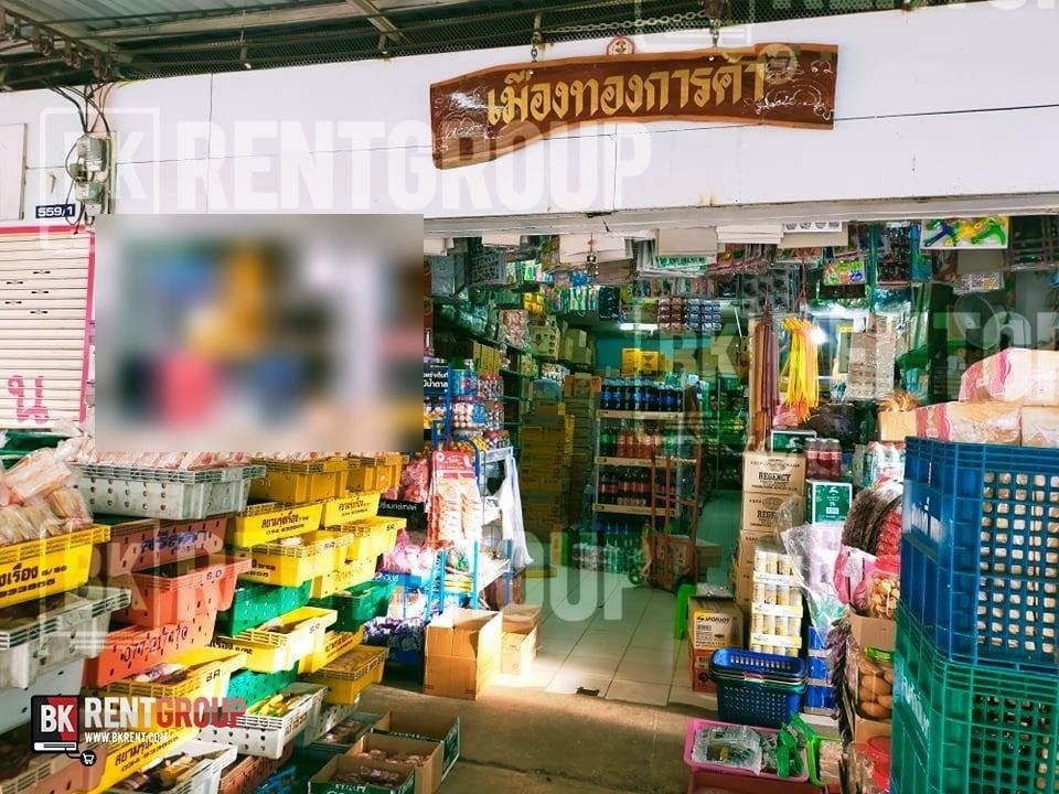 หน้าร้านเมืองทองการค้า ป้ายไม้ชื่อร้าน ตะกร้าขนมและลังเครื่องดื่มวางซ้อนกันหน้าทางเข้า