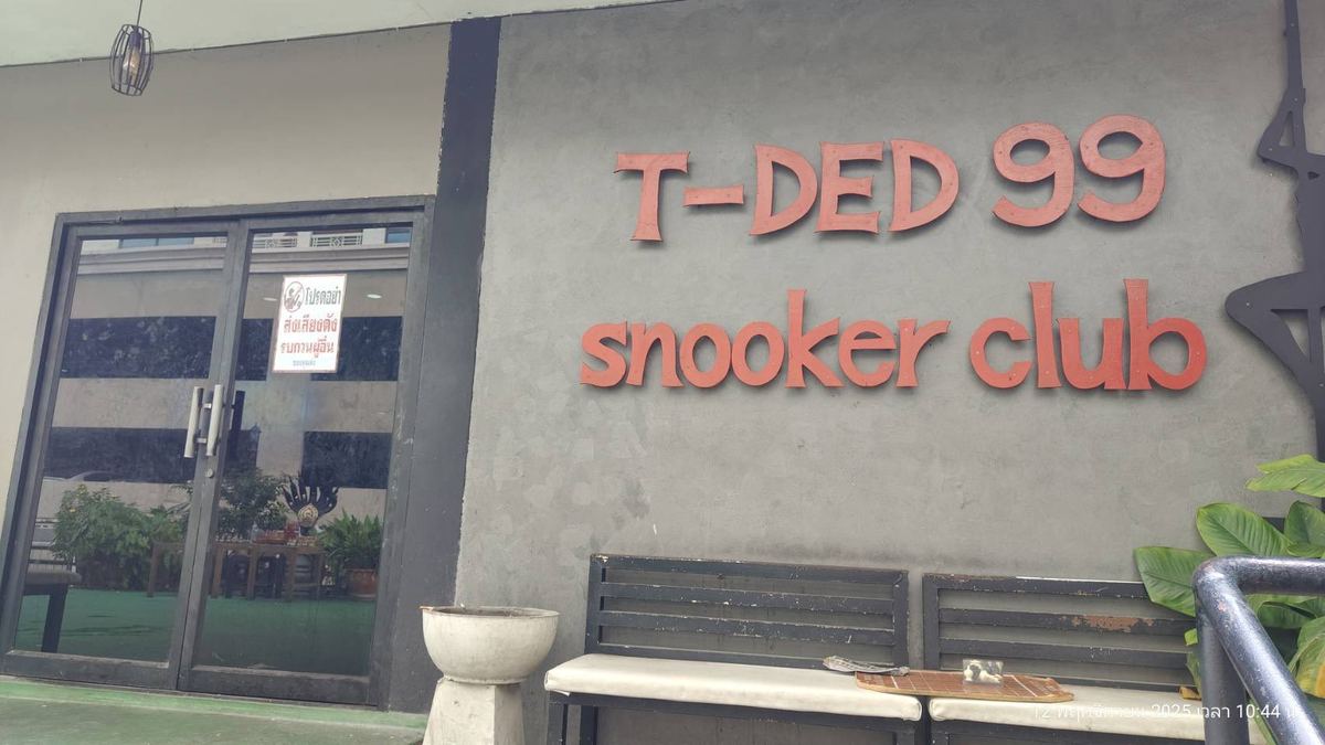 หน้าร้าน T-DED 99 Snooker Club มีป้ายชื่อร้านตัวอักษรสีแดงบนผนังสีเทา ข้างประตูกระจก